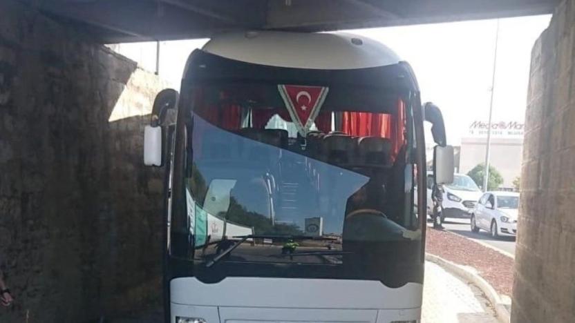 AKP'lileri taşıyan otobüs alt geçitte sıkıştı: Lastikleri indirilerek kurtarıldı