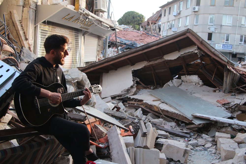 Deprem öncesi müzik yaptığı sokakta, bu kez enkaz önünde 'Hatıran Yeter' şarkısını söyledi